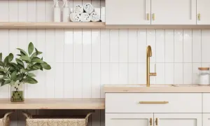 A modern laundry room with white subway tiles and subtle grout options. A gold faucet and brass hardware add a touch of luxury.