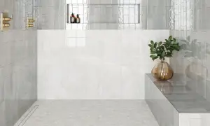 Modern shower with hexagonal subway tile on floor, marble wall, and glass shower walls.