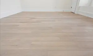 Light wood vinyl plank flooring laid in a room. This image shows the result of how to start vinyl plank flooring, with clean lines and a modern look.