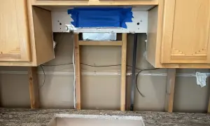 Kitchen renovation in progress. The area above the countertop is exposed, showing studs and wiring. This is the perfect time to consider if you need backer board for backsplash.