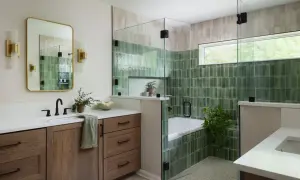A modern bathroom features a soaking tub surrounded by glossy green and beige modern bathroom tiles, a glass shower enclosure, and a wooden vanity.