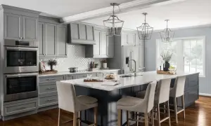 A modern gray kitchen with a large island, featuring dark wood floors, the best flooring for kitchens and bathrooms.