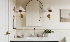 A modern bathroom with a large arched mirror above a 36-inch vanity. The mirror is framed in black and reflects a showerhead.