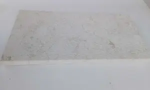 A textured, off-white limestone slab, showing some discoloration. This image could illustrate how to clean limestone.