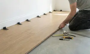 Installing vinyl plank flooring. Spacers are used to maintain an expansion gap around the perimeter, crucial for how to clean vinyl plank flooring properly later.