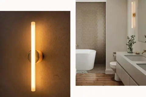 Modern wall sconces, like this sleek vertical tube light, prove they are far from out of style, adding a warm glow to a contemporary bathroom.