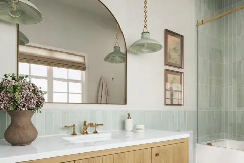 A modern bathroom with a light green vertical tile backsplash placement behind a white sink and vanity.