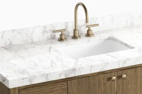 A modern bathroom vanity with a white sink, brass faucet, and a white marble countertop. This image showcases a stylish option to replace bathroom countertop.