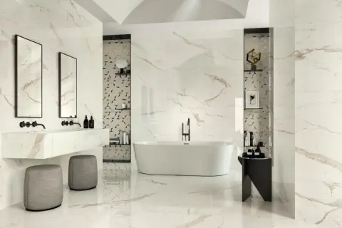 Luxurious bathroom with marble-look tiles featuring thin grout lines vs thick. A freestanding tub, double vanity, and modern stools create a spa-like atmosphere.