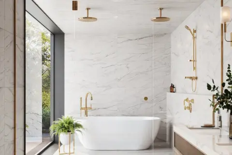 A luxurious bathroom featuring white marble tile with light grey grout, a freestanding tub, and gold fixtures.