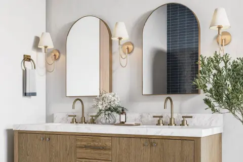 A modern double vanity with marble countertop, brass fixtures, and arched mirrors. The image hints at ideal double vanity dimensions for a spacious bathroom.