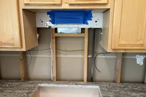 Kitchen renovation in progress. The area above the countertop is exposed, showing studs and wiring. This is the perfect time to consider if you need backer board for backsplash.