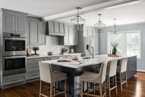 A modern gray kitchen with a large island, featuring dark wood floors, the best flooring for kitchens and bathrooms.