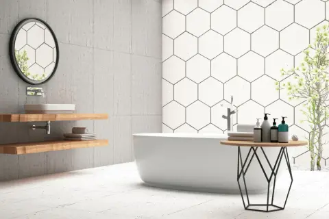 Modern bathroom with a freestanding tub, hexagonal wall tiles, and light-colored floor tiles. Ceramic tile is good for bathroom floors, offering durability and style.