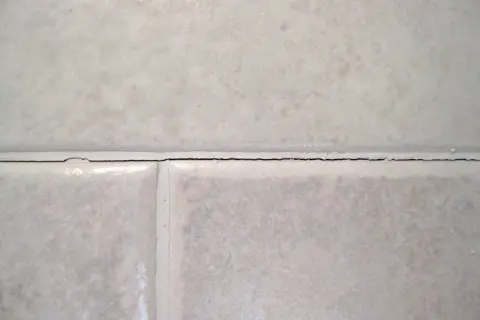 Cracked grout between tiles. It's not normal for grout to crack, indicating potential issues with installation or movement.