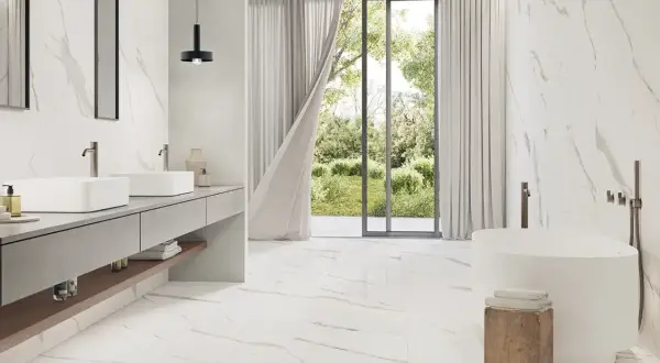 A modern bathroom with Carrara marble tiles. The best grout color for Carrara marble is subtle, allowing the natural veining to shine.