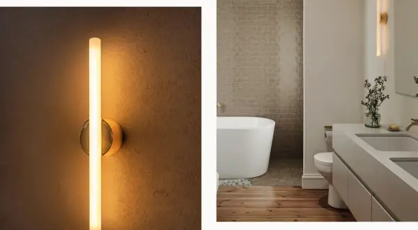 Modern wall sconces, like this sleek vertical tube light, prove they are far from out of style, adding a warm glow to a contemporary bathroom.