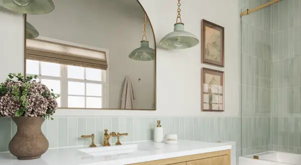 A modern bathroom with a light green vertical tile backsplash placement behind a white sink and vanity.