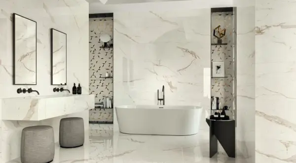 Luxurious bathroom with marble-look tiles featuring thin grout lines vs thick. A freestanding tub, double vanity, and modern stools create a spa-like atmosphere.