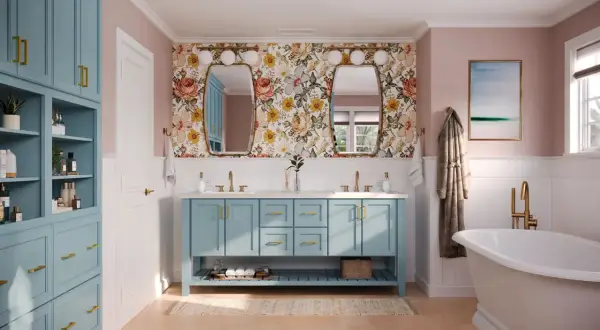 A bright bathroom with a floral wallpaper, a blue double vanity, and a freestanding tub. This blue is a beautiful choice for the best color for bathroom cabinets.