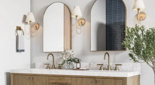 A modern double vanity with marble countertop, brass fixtures, and arched mirrors. The image hints at ideal double vanity dimensions for a spacious bathroom.