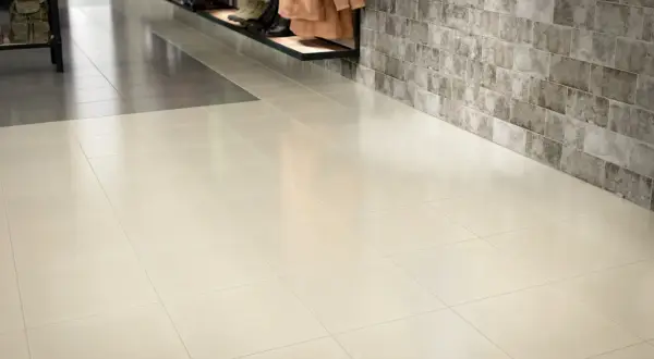 A clean, polished floor showcases how to make porcelain tile shine. The light-colored tiles reflect the light, creating a bright and inviting space.
