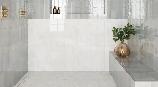 Modern shower with hexagonal subway tile on floor, marble wall, and glass shower walls.