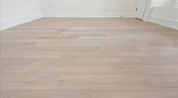 Light wood vinyl plank flooring laid in a room. This image shows the result of how to start vinyl plank flooring, with clean lines and a modern look.