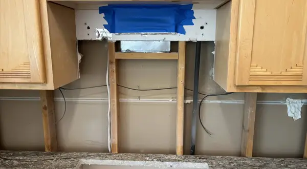 Kitchen renovation in progress. The area above the countertop is exposed, showing studs and wiring. This is the perfect time to consider if you need backer board for backsplash.