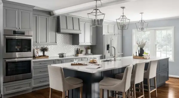 A modern gray kitchen with a large island, featuring dark wood floors, the best flooring for kitchens and bathrooms.