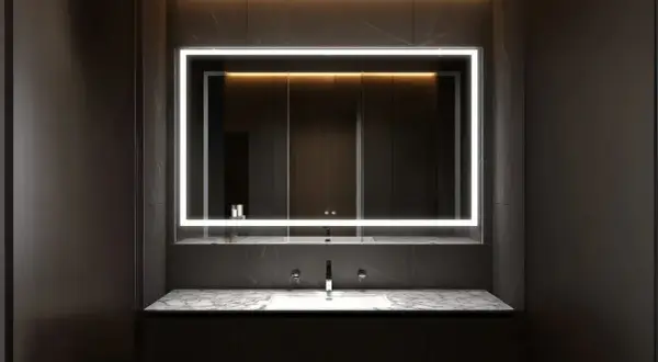 Modern bathroom mirror trends: a sleek, illuminated rectangle above a marble vanity with dual sinks and chrome faucets.