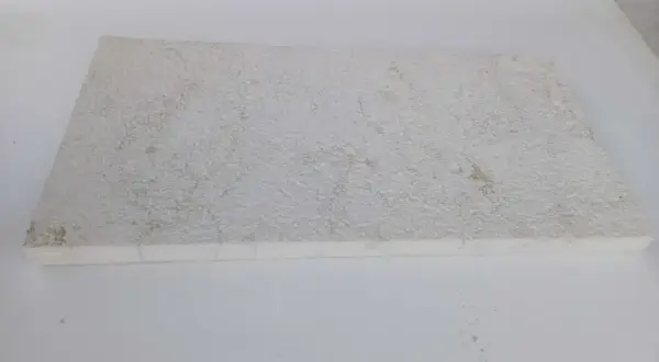 A textured, off-white limestone slab, showing some discoloration. This image could illustrate how to clean limestone.