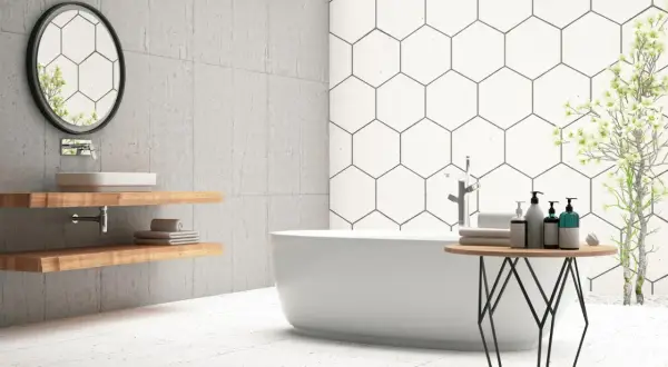Modern bathroom with a freestanding tub, hexagonal wall tiles, and light-colored floor tiles. Ceramic tile is good for bathroom floors, offering durability and style.