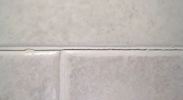 Cracked grout between tiles. It's not normal for grout to crack, indicating potential issues with installation or movement.