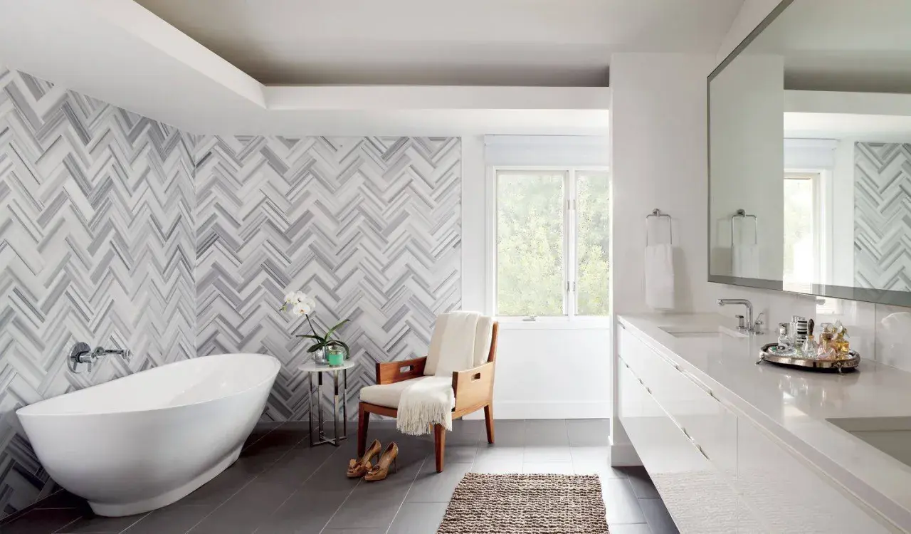 A luxurious bathroom features a freestanding tub and a stunning herringbone pattern shower wall.