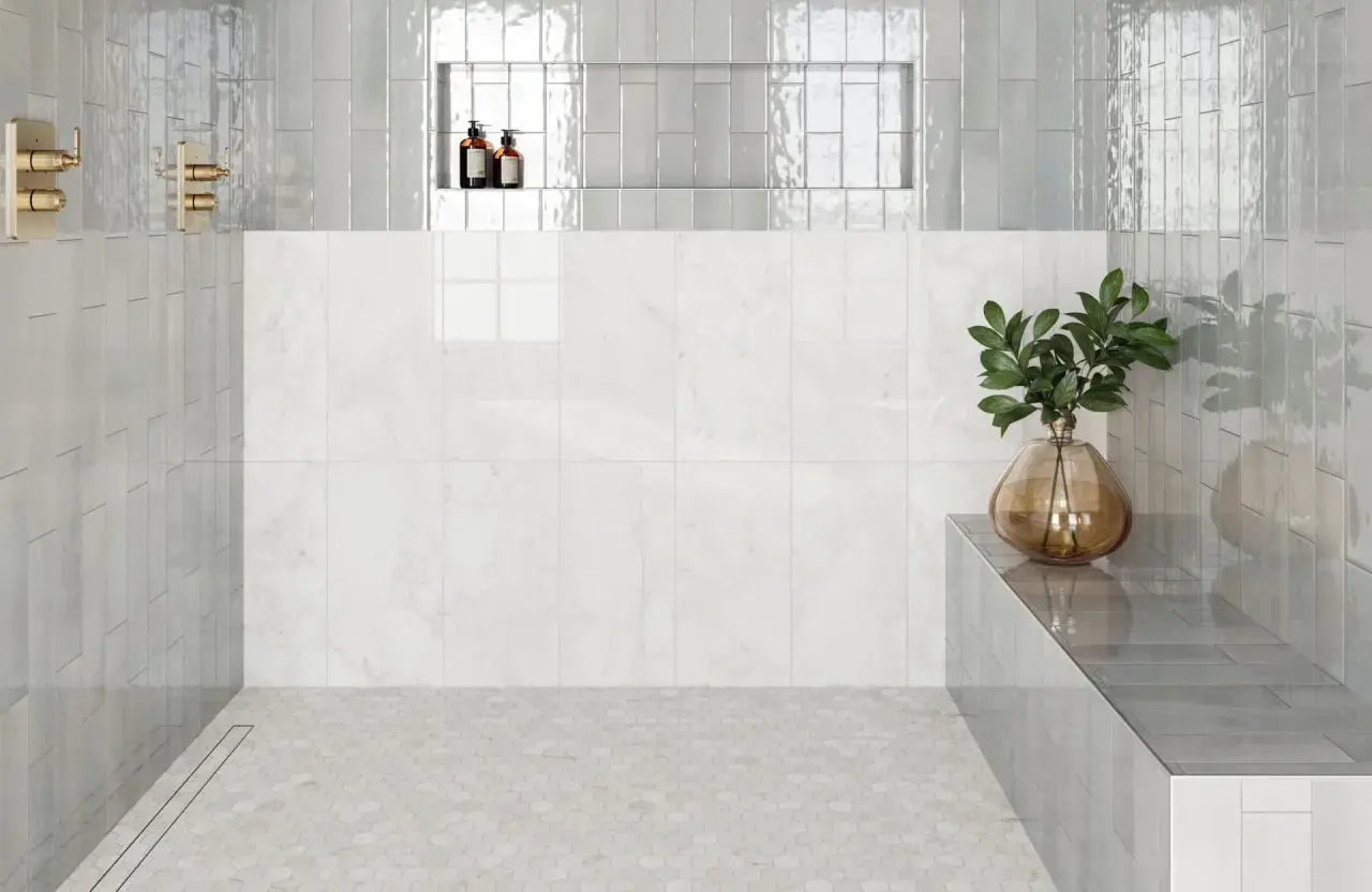 Modern shower with hexagonal subway tile on floor, marble wall, and glass shower walls.