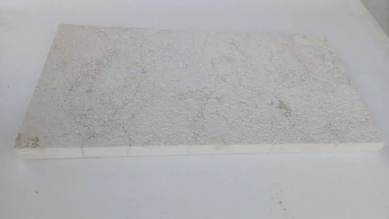A textured, off-white limestone slab, showing some discoloration. This image could illustrate how to clean limestone.