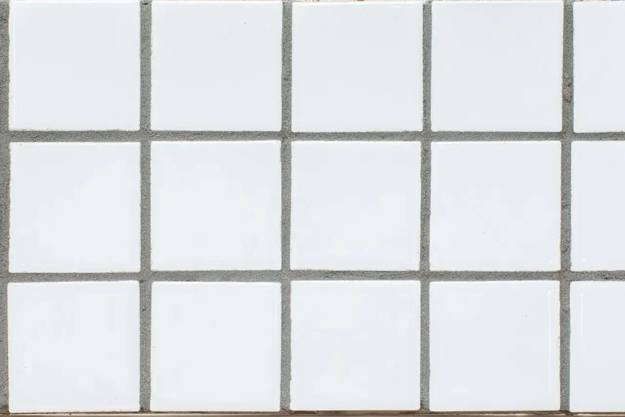 A grid of small, white square tiles with gray grout filling the spaces between them. This is what grout looks like.