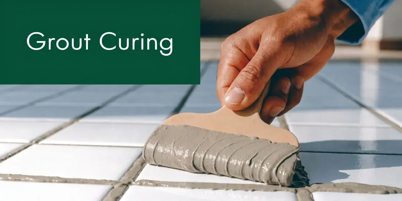 A hand applies grout to white tiles. Learn how long for grout to dry for a perfect finish.