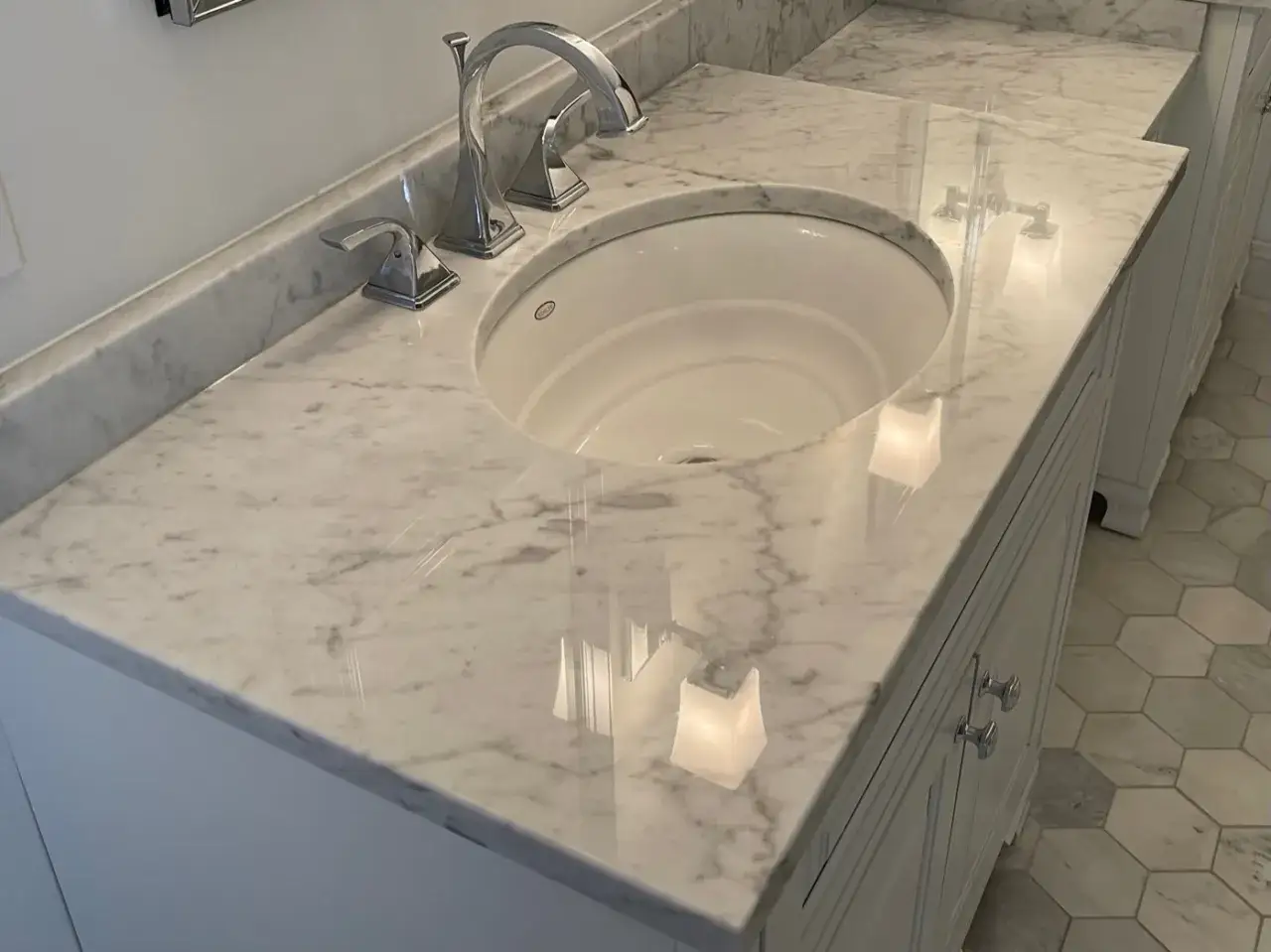 A gleaming white marble vanity with a modern chrome faucet. To keep it pristine, use pH-neutral cleaners.