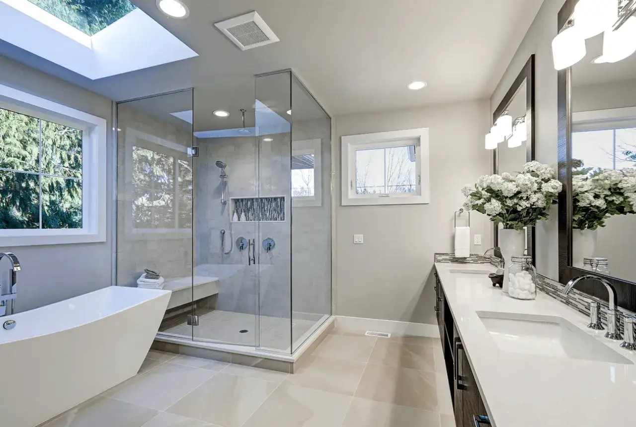 Modern bathroom with a freestanding tub, glass-enclosed shower, and double vanity. The tile work looks freshly done, suggesting a recent re grouting project.