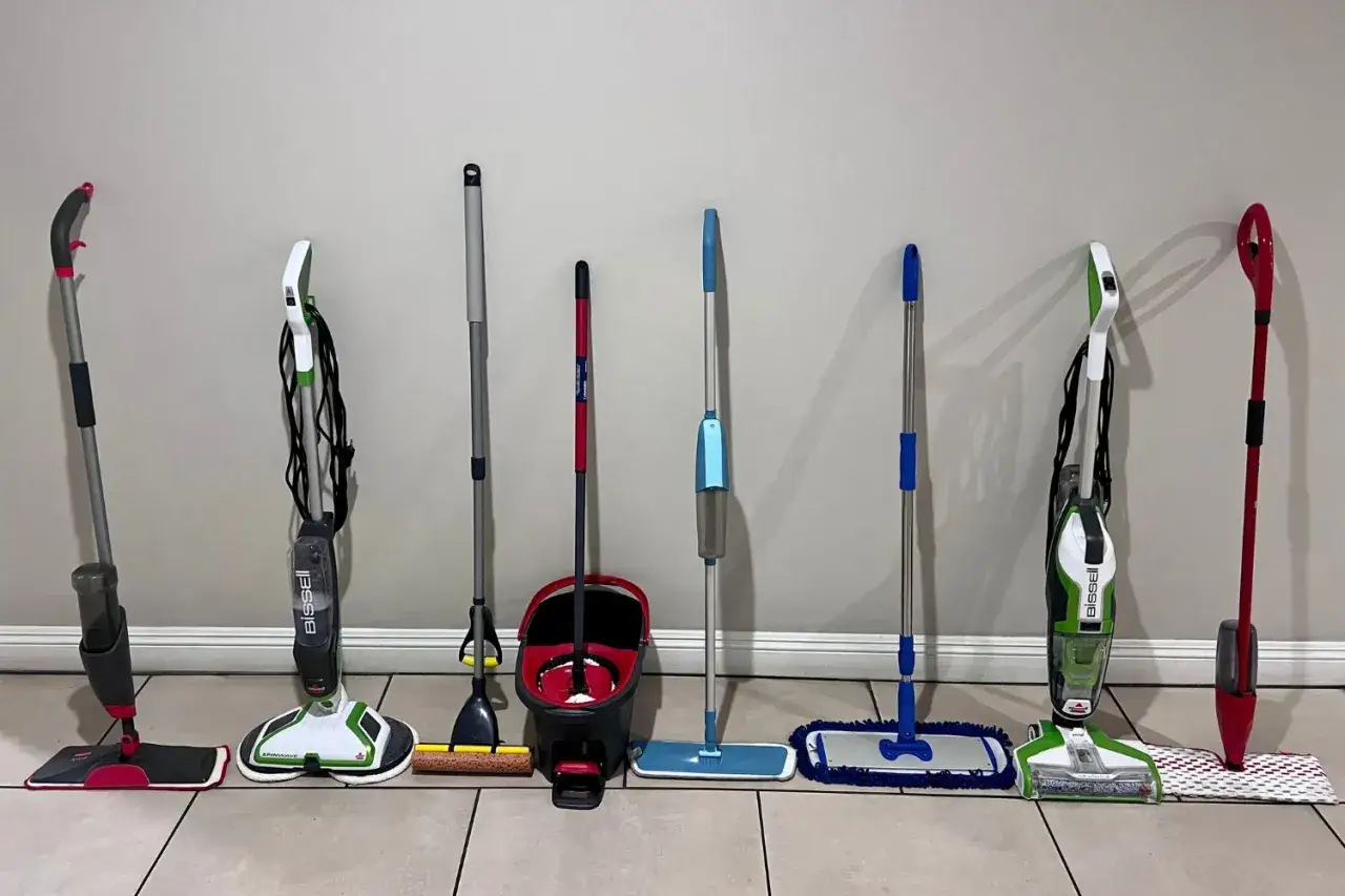 A collection of mops and cleaning tools, showcasing various methods for how to clean vinyl plank flooring.