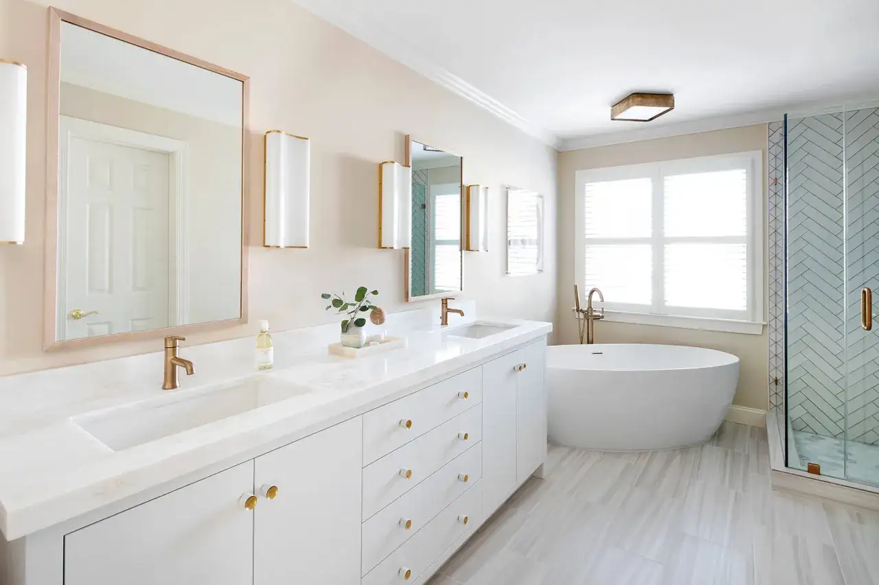 A modern, fully tiled bathroom featuring a freestanding tub, double vanity, and a glass-enclosed shower.