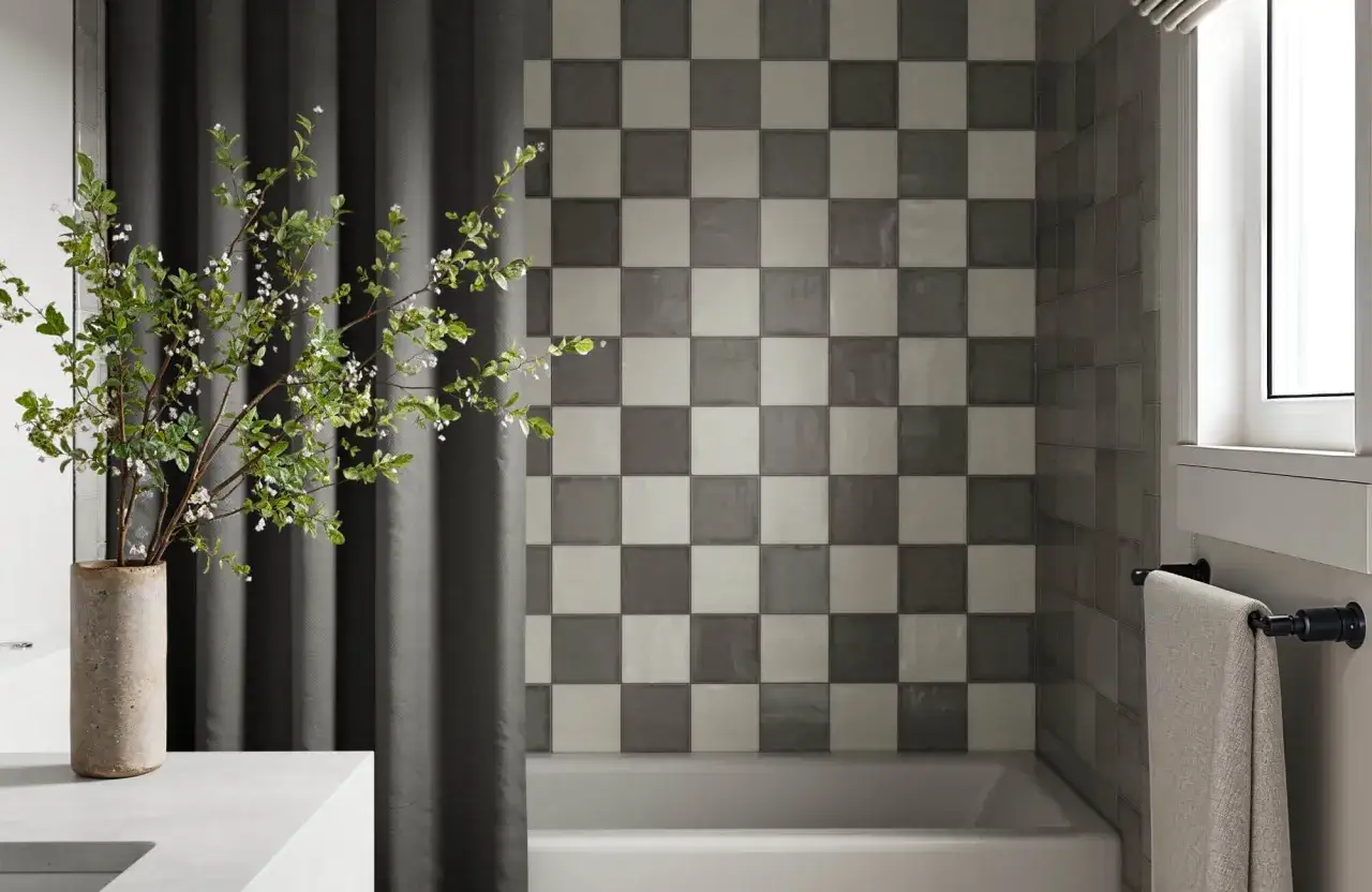 A modern bathroom features a black and white checkerboard tile wall. The grout color appears to be a light gray, complementing the tiles.