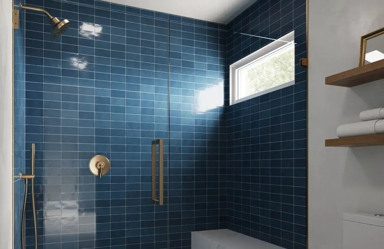 A modern shower with deep blue, low maintenance shower tile, brass fixtures, and a small window.