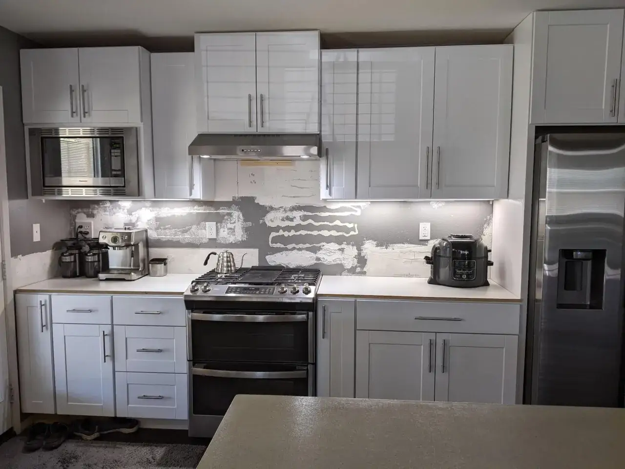 Kitchen renovation in progress. The wall behind the stove shows exposed drywall, hinting at the question: do you need backer board for backsplash?