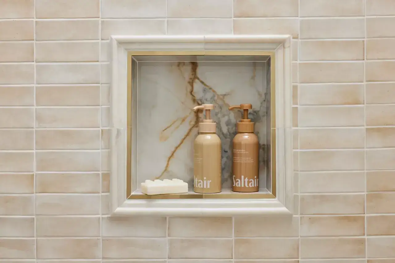 Elegant subway tile edge options frame a marble niche with bath products.