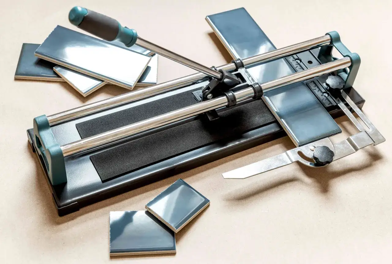 A manual tile cutter with blue ceramic tiles, ready to demonstrate how to cut ceramic tile by hand.