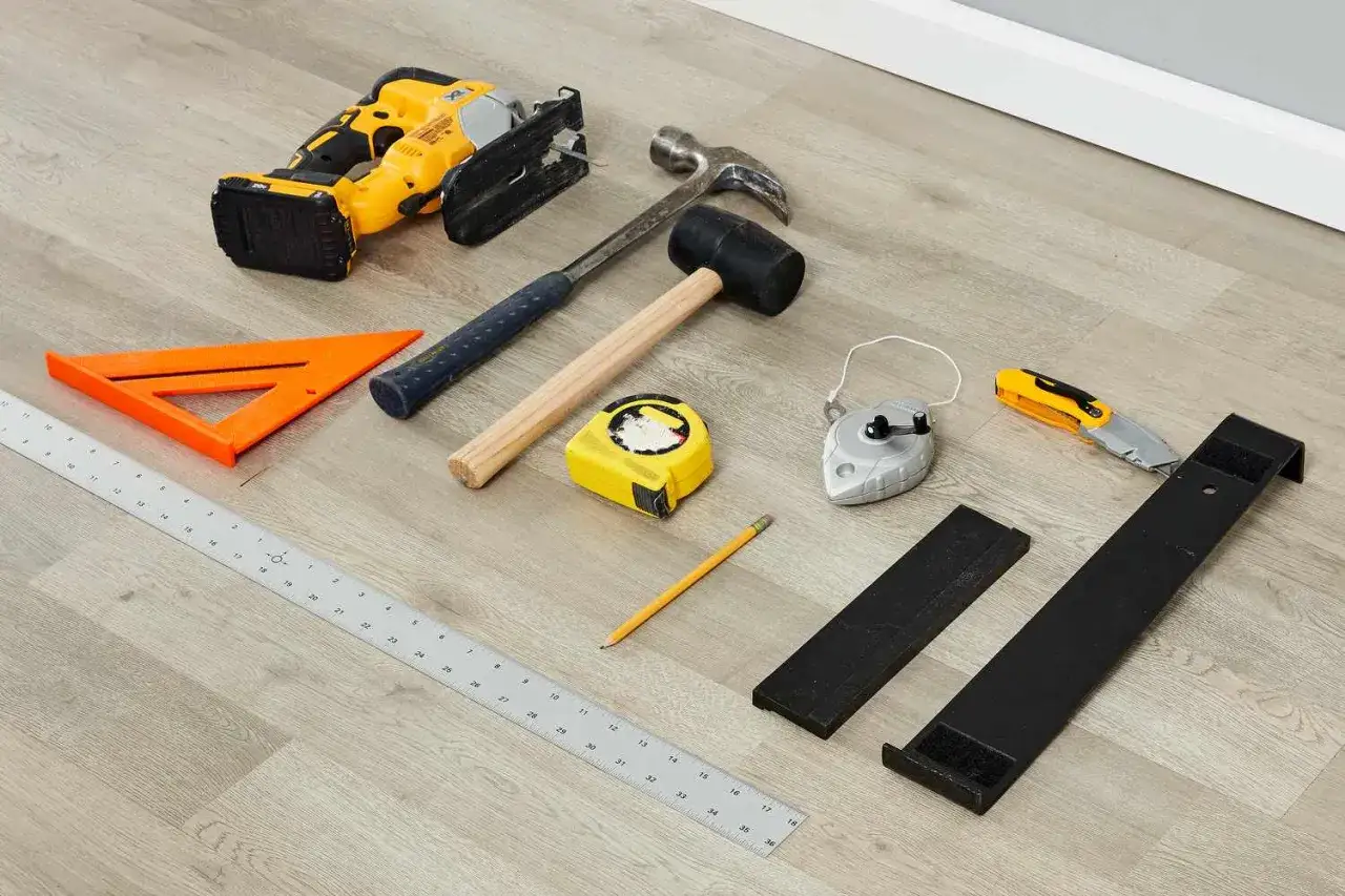 Tools for how to install laminate flooring: jigsaw, hammers, tape measure, pencil, ruler, chalk line, utility knife, and flooring installation tools.
