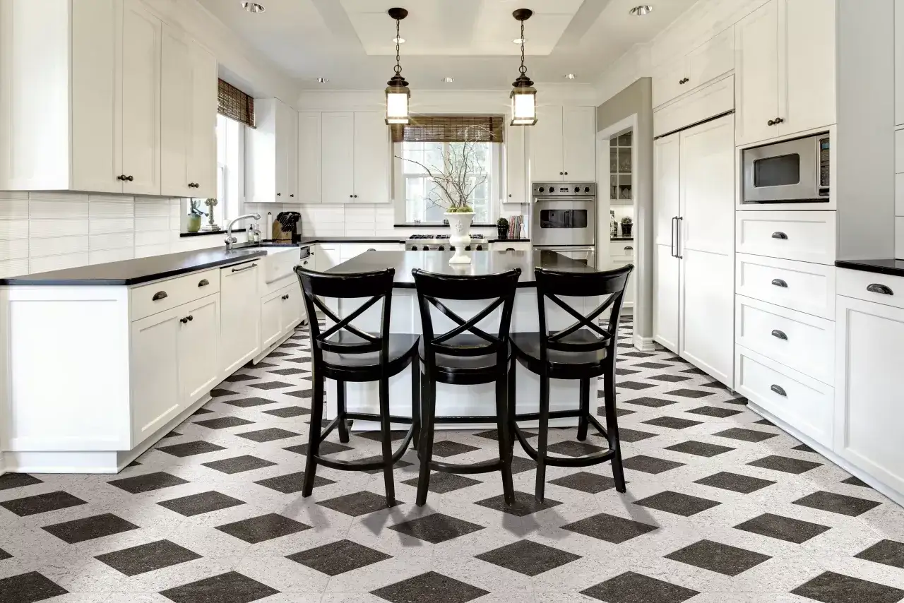 A modern kitchen with white cabinets and a striking geometric pattern of kitchen floor tile patterns in black and white.